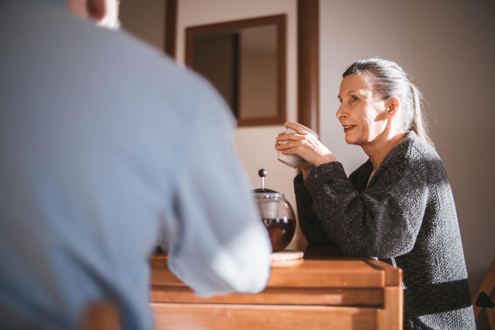 An older adult shares a relaxed conversation while administrative details are coordinated with care.